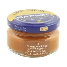 Saphir Crème Surfine hair styling cream in a round glass jar with a blue and gold lid and orange-brown cream visible inside.